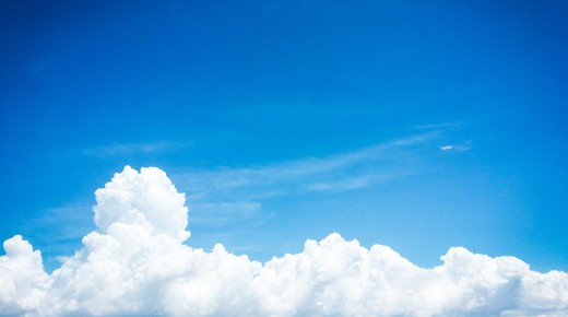 A plain blue sky with a white cloud.