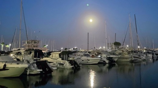 Boats docked at night in the harbor of Nettuno, Italy.