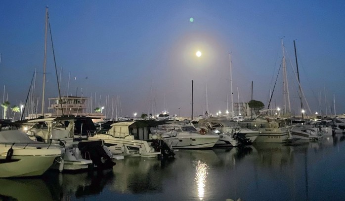 Boats docked at night in the harbor of Nettuno, Italy.
